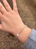 Hand with a bracelet on a blurred natural background